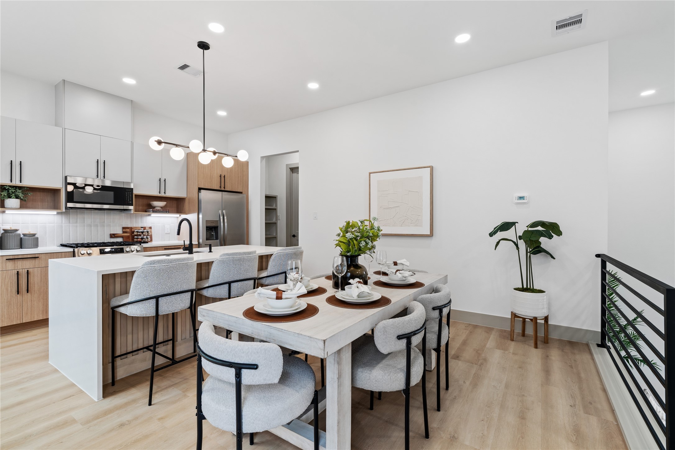 a kitchen with a dining table chairs stainless steel appliances and cabinets