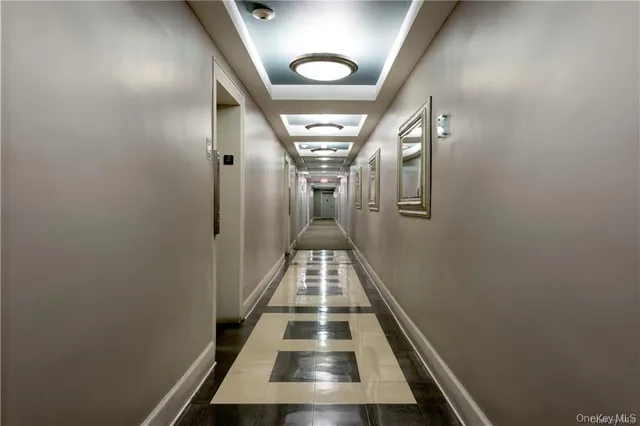a view of hallway with closet and wooden floor