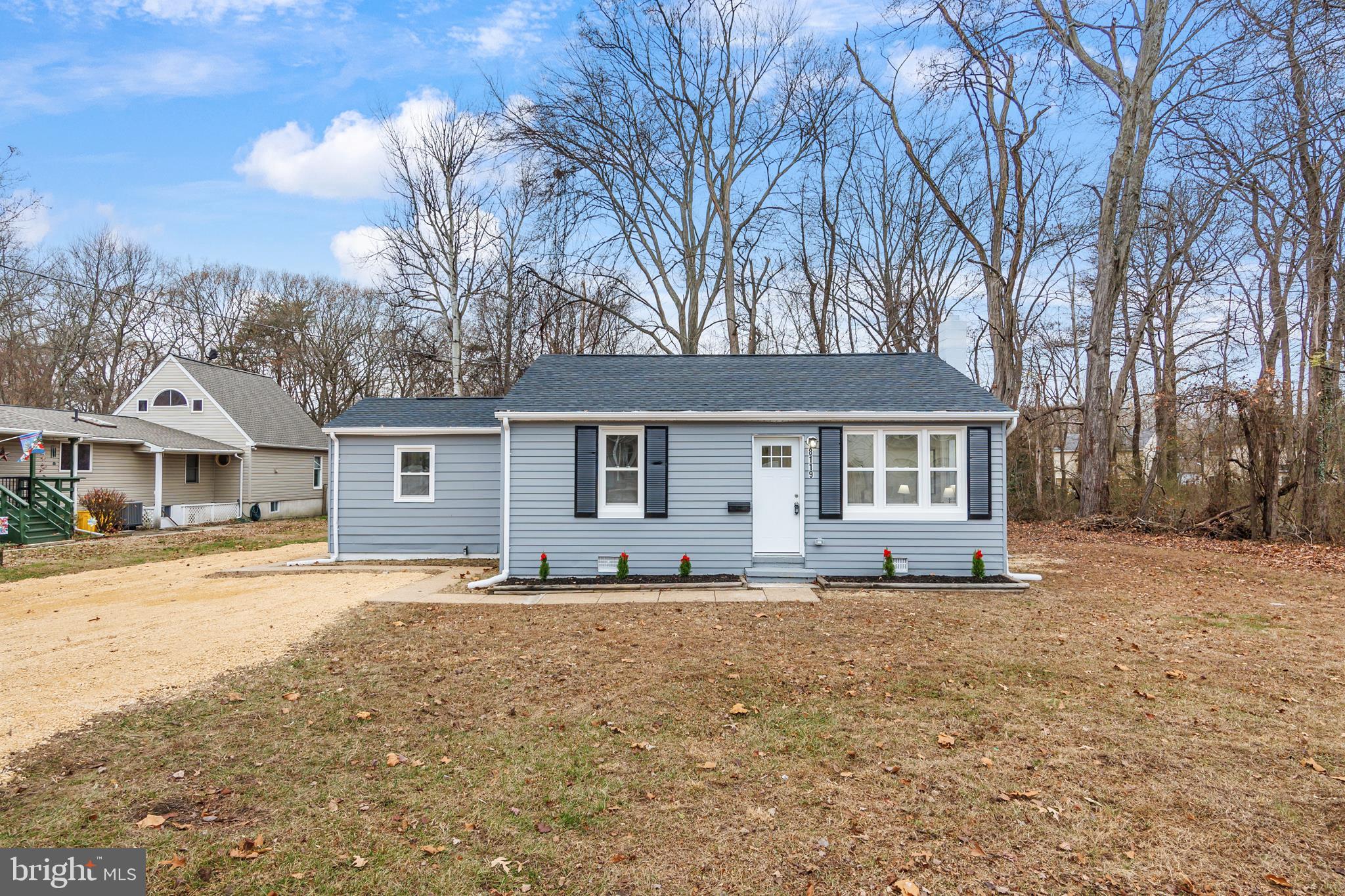 a front view of a house with a yard and trees