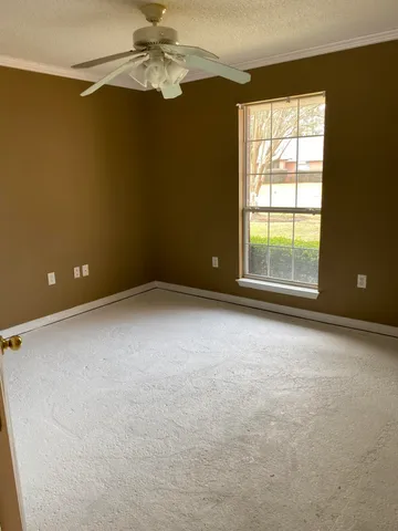 en empty room with windows and chandelier fan