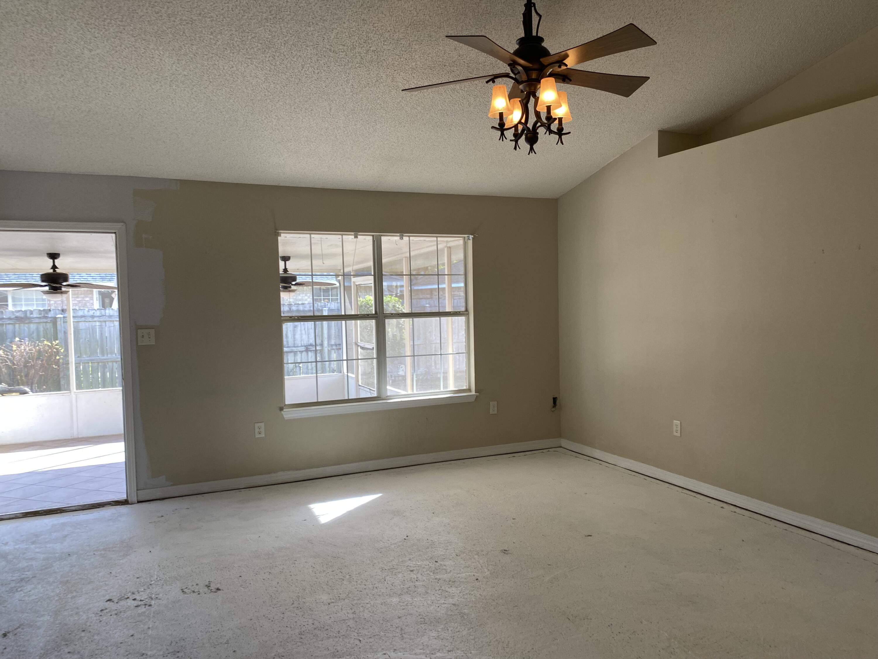 175 Beacon Way Miramar Beach, FL 32550 - Photo 2 of 26 an empty room with windows and chandelier fan