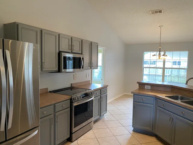 a kitchen with granite countertop a stove and a refrigerator