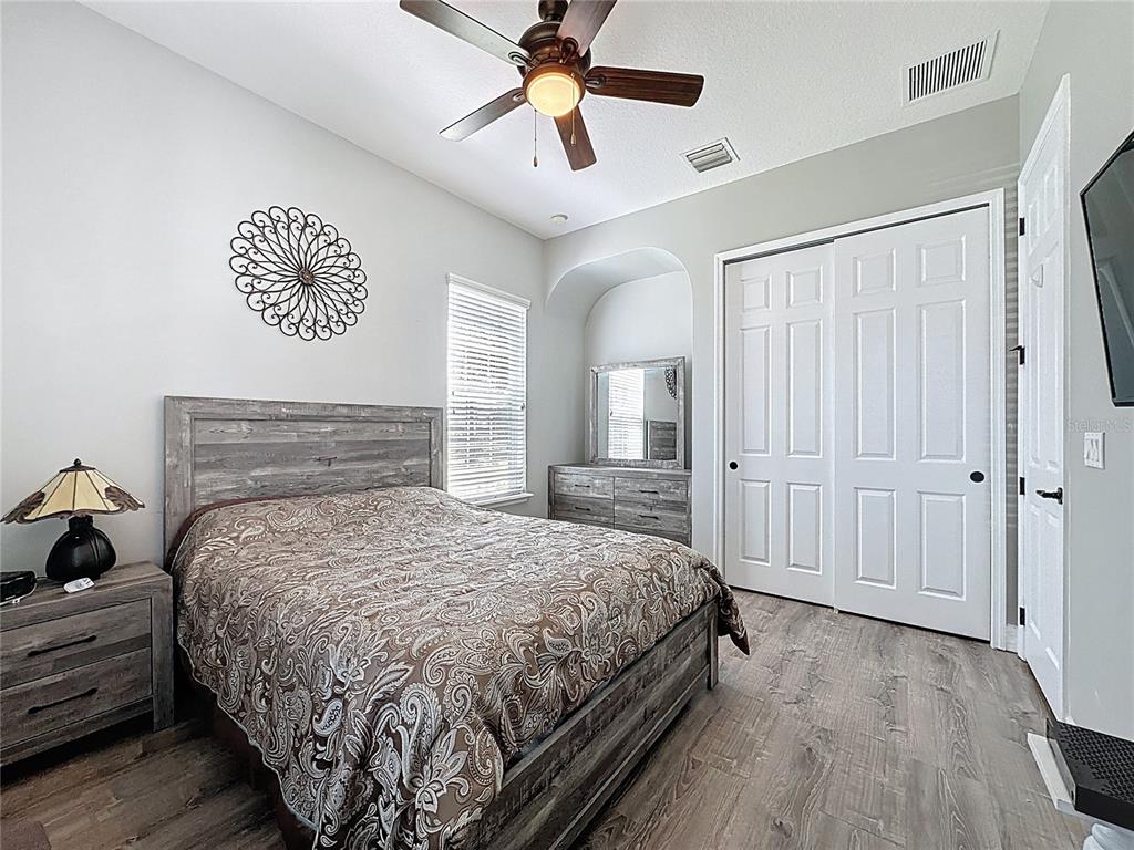 228 Bayou Bend Road Groveland, FL 34736 - Photo 24 of 54 a bedroom with a bed and a chandelier