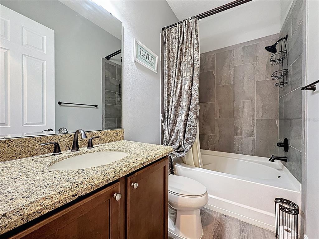 228 Bayou Bend Road Groveland, FL 34736 - Photo 25 of 54 a bathroom with a granite countertop bathtub sink vanity mirror and toilet