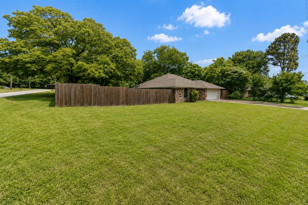 1001 Rosebud Drive Azle, TX 76020 - Photo 3 of 36 Expansive front lawn with a privacy fence bordering the property