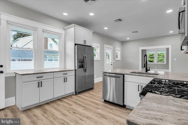 a view of a kitchen with a sink granite counter tops and a window