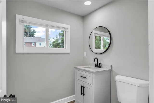 a bathroom with a toilet sink and mirror
