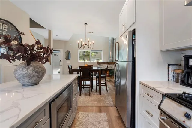 a kitchen with stainless steel appliances granite countertop a sink a stove and a refrigerator