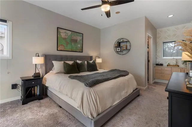 a bedroom with a bed flat screen tv and a window