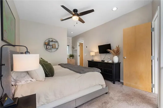 a bedroom with a bed and a flat tv screen on dresser