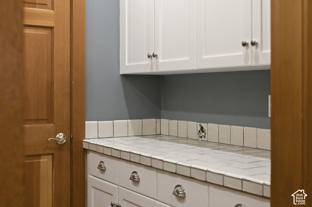 725 Canyon Road Smithfield, UT 84335 - Photo 39 of 100 White shaker-style cabinetry with chrome hardware, tile countertop, and a tiled backsplash featuring an accent tile