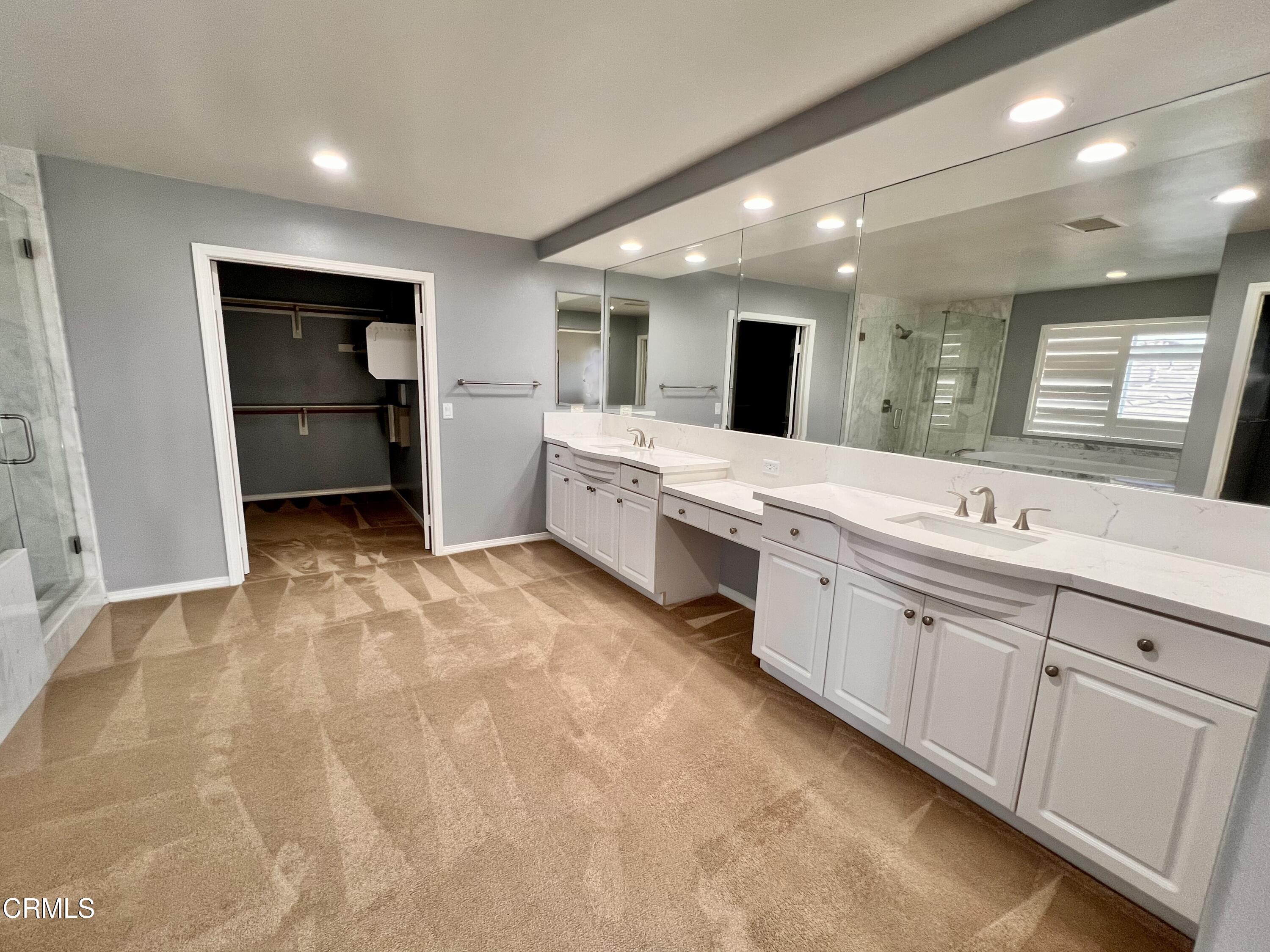 652 Corte Elegante Camarillo, CA 93010 - Photo 12 of 18 a large white bathroom with a large mirror vanity and shower