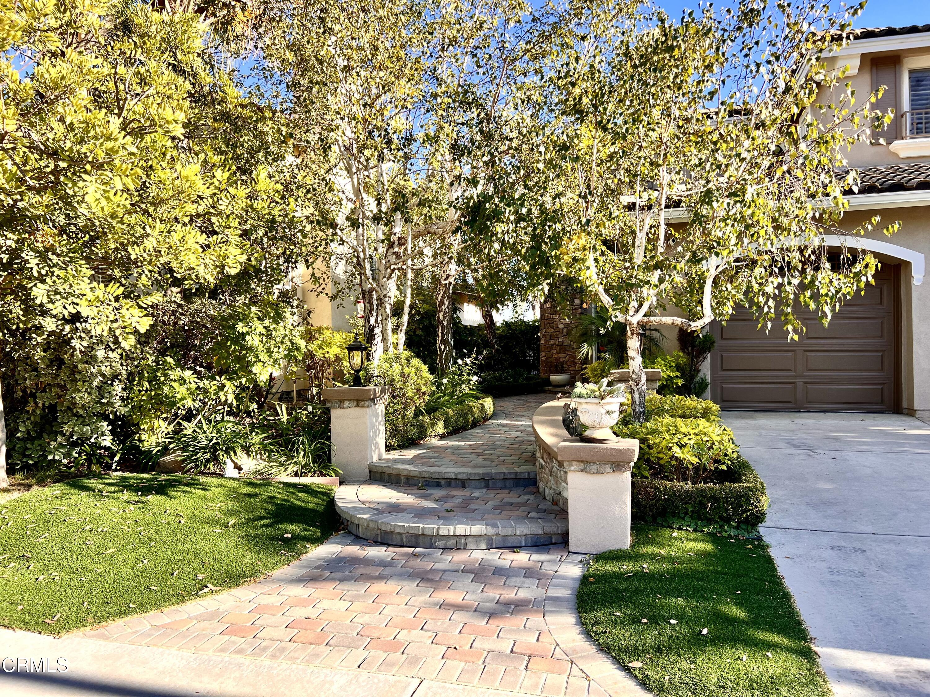 652 Corte Elegante Camarillo, CA 93010 - Photo 3 of 18 a view of a white house with a yard and potted plants