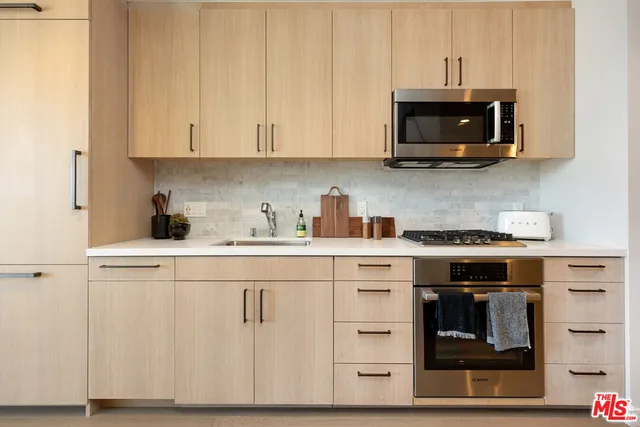 a kitchen with stainless steel appliances granite countertop a stove a microwave and a refrigerator