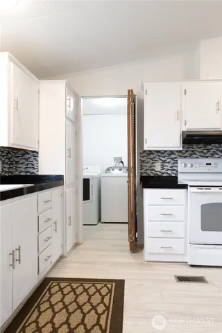 a kitchen with white cabinets and white appliances