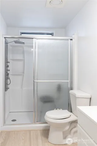 a white toilet sitting next to a shower