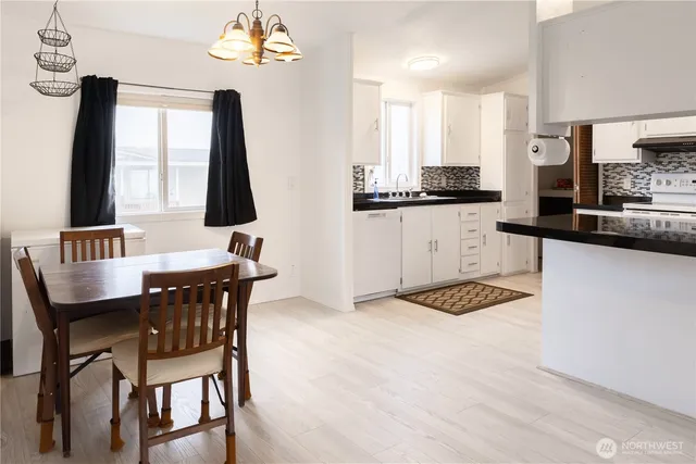 a kitchen with a dining table chairs and a refrigerator