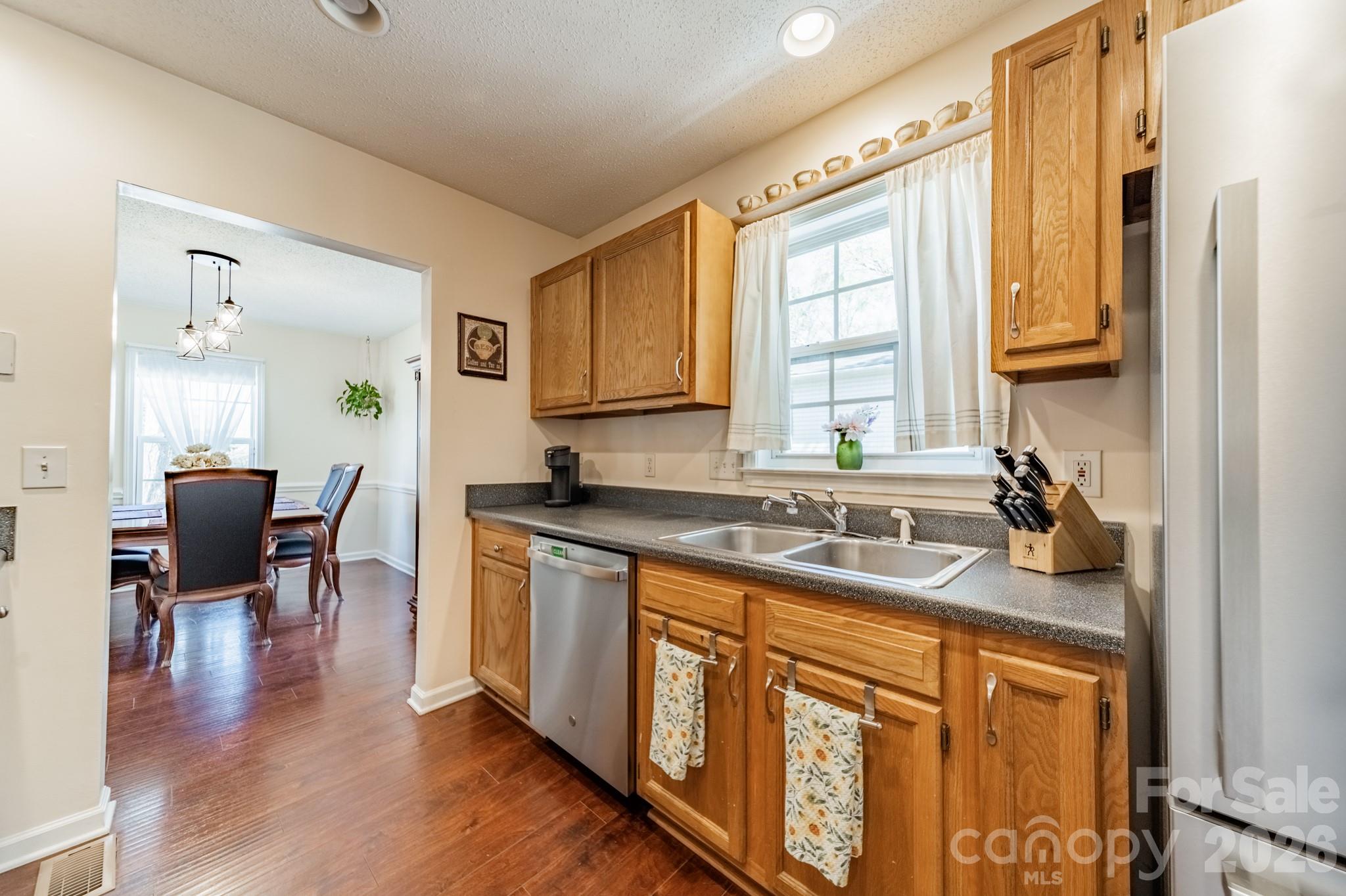 1015 South Walnut Street Kannapolis, NC 28081 - Photo 7 of 19 a kitchen with stainless steel appliances granite countertop wooden cabinets a sink a stove a dining table and chairs