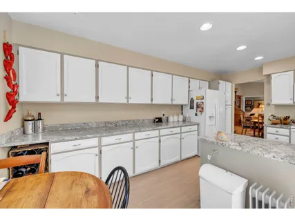 a kitchen with stainless steel appliances granite countertop a refrigerator and a stove top oven
