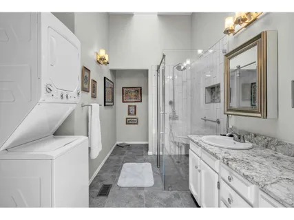 a large bathroom with a granite countertop sink a toilet a mirror and shower