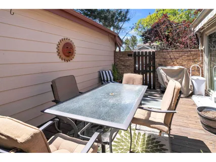 a view of backyard with table and chairs and wooden fence