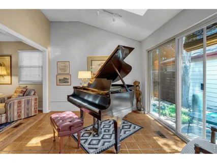 a living room with furniture a floor to ceiling window and a flat screen tv