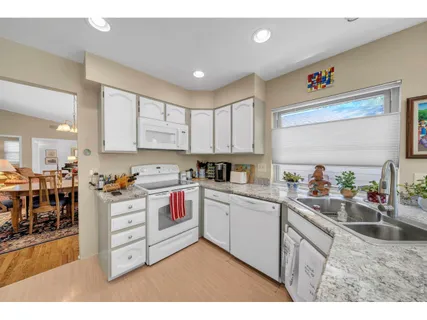 a kitchen with stainless steel appliances sink cabinets and window