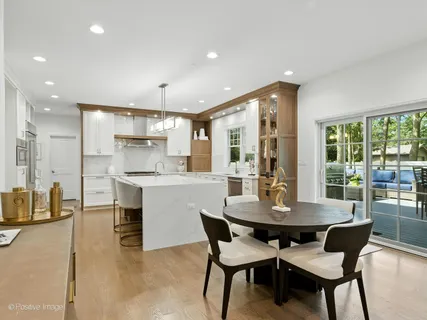 a kitchen with kitchen island a table and chairs in it