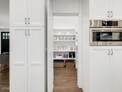 a view of a hallway with wooden floor and windows
