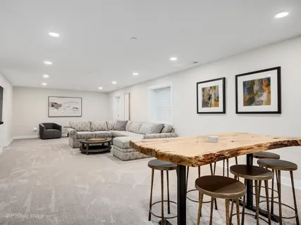 a view of a patio with couches and a table and chairs with wooden floor and fence