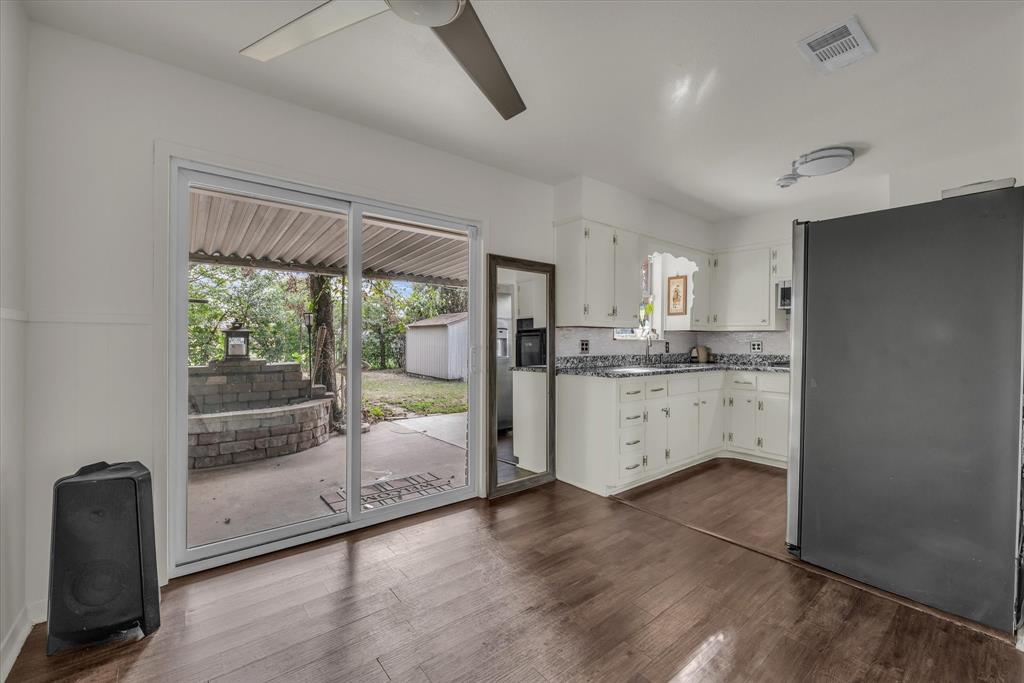 309 South Rita Street Lacy-Lakeview, TX 76705 - Photo 4 of 19 a kitchen with white cabinets and wooden floor