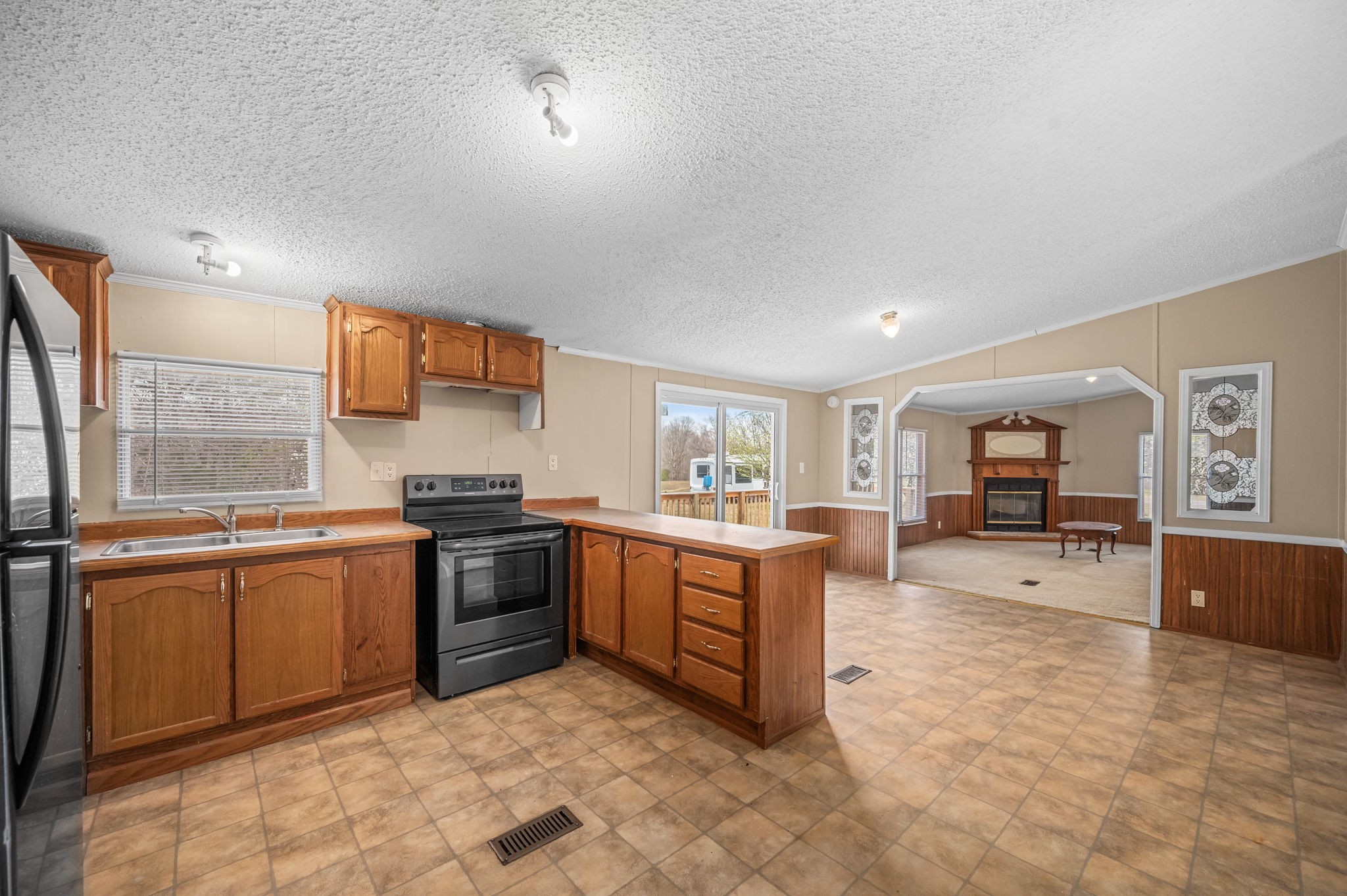 1174 Throneberry Road Normandy, TN 37360 - Photo 10 of 29 a kitchen with stainless steel appliances granite countertop a stove top oven a sink a dining table and chairs with the front door