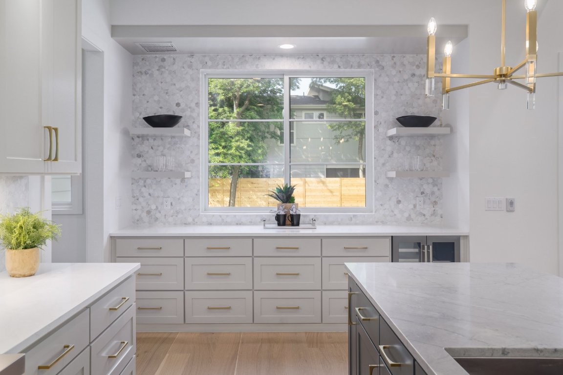 1703 Piedmont Avenue Austin, TX 78757 - Photo 12 of 37 a kitchen with a sink dishwasher a stove and white cabinets