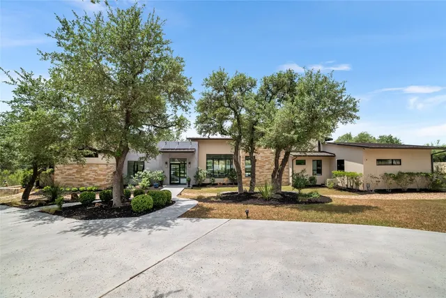 a front view of a house with a yard and trees