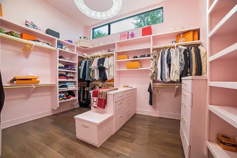 a view of walk in closet with clothes and shoes