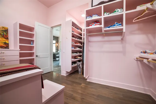 a view of walk in closet with clothes and shoes