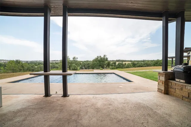 a view of swimming pool with a patio and a yard