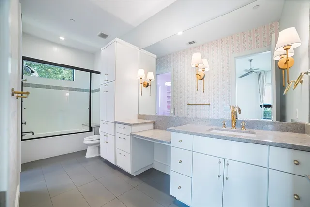 a bathroom with a double vanity sink toilet and mirror