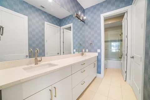 a bathroom with a double vanity sink and mirror