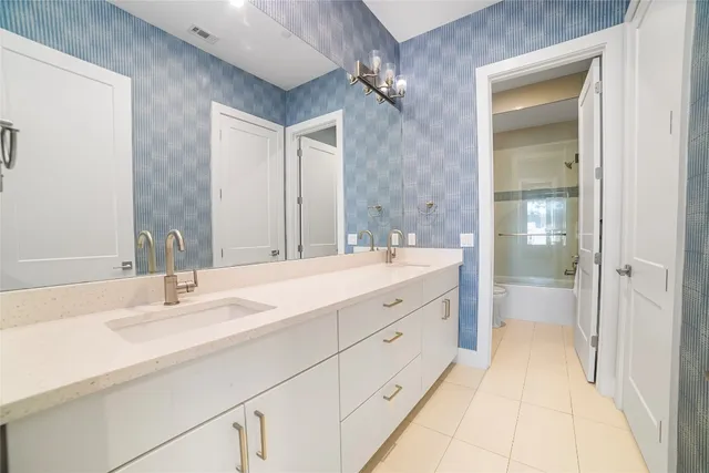 a bathroom with a double vanity sink and mirror