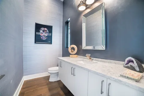 a bathroom with a granite countertop sink a toilet and a mirror