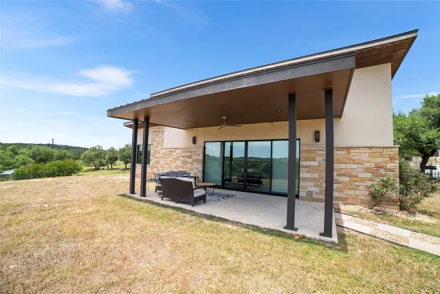 a patio with table and chairs and potted plants