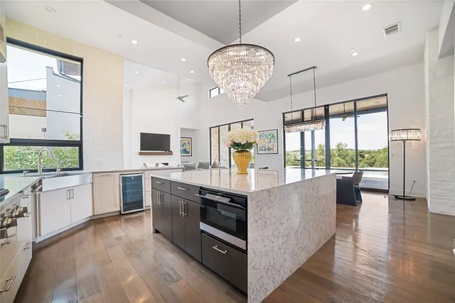 a large kitchen with stainless steel appliances granite countertop a stove oven and a large window