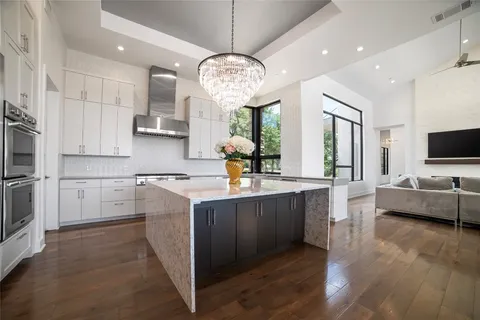 a large kitchen with kitchen island granite countertop a stove oven and a view of living room