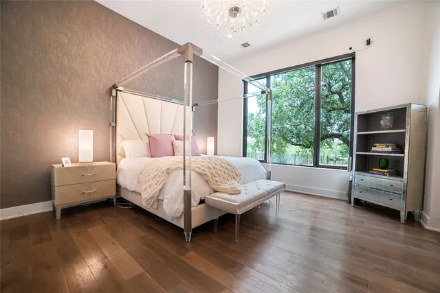 a bed sitting in a spacious bedroom next to a window