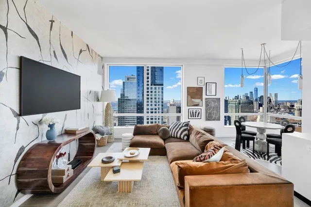 a living room with furniture wooden floor and a flat screen tv