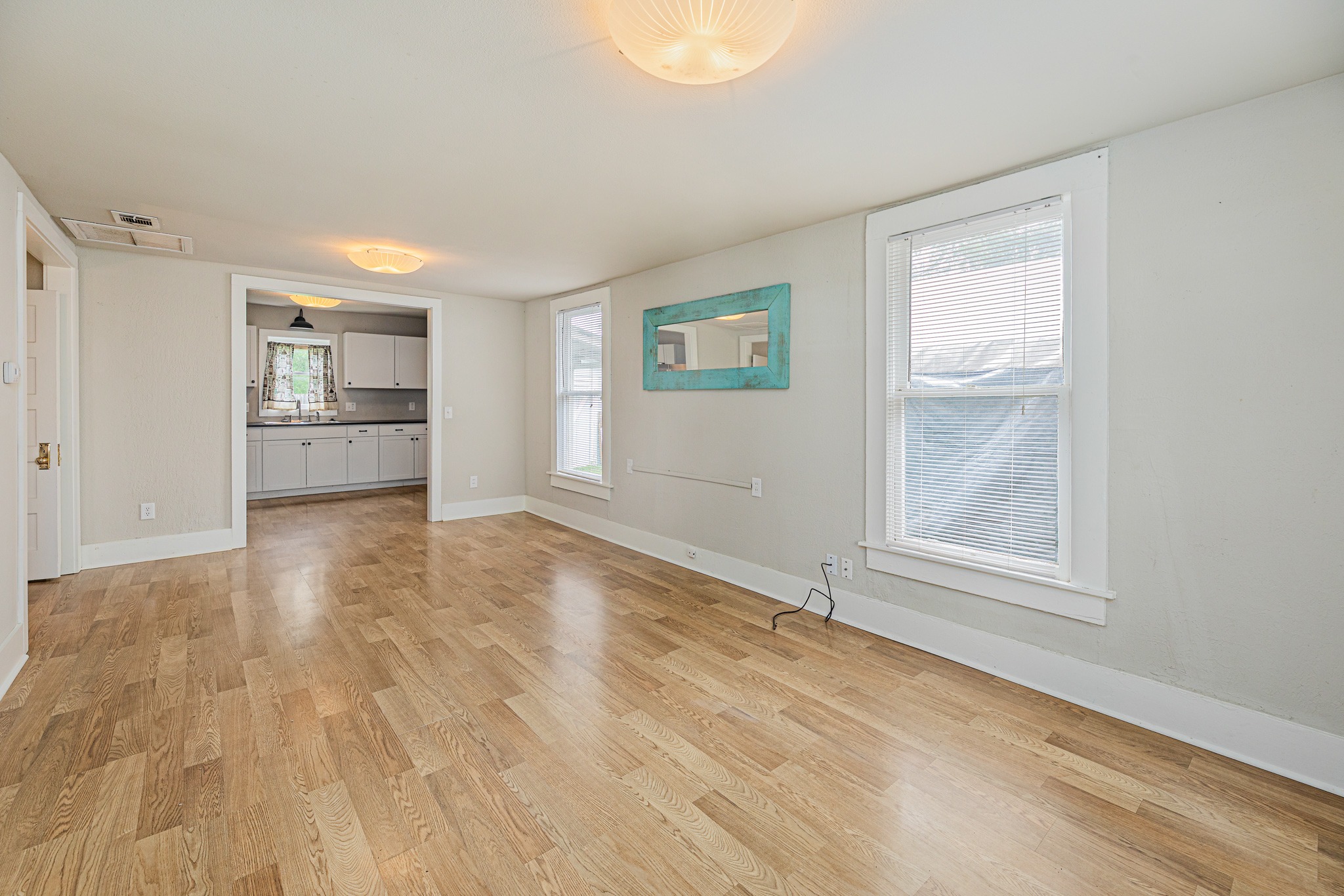 322 Blanco Avenue Luling, TX 78648 - Photo 3 of 20 Luminous living area with rich hardwood flooring, offering an effortless flow into the adjacent kitchen.