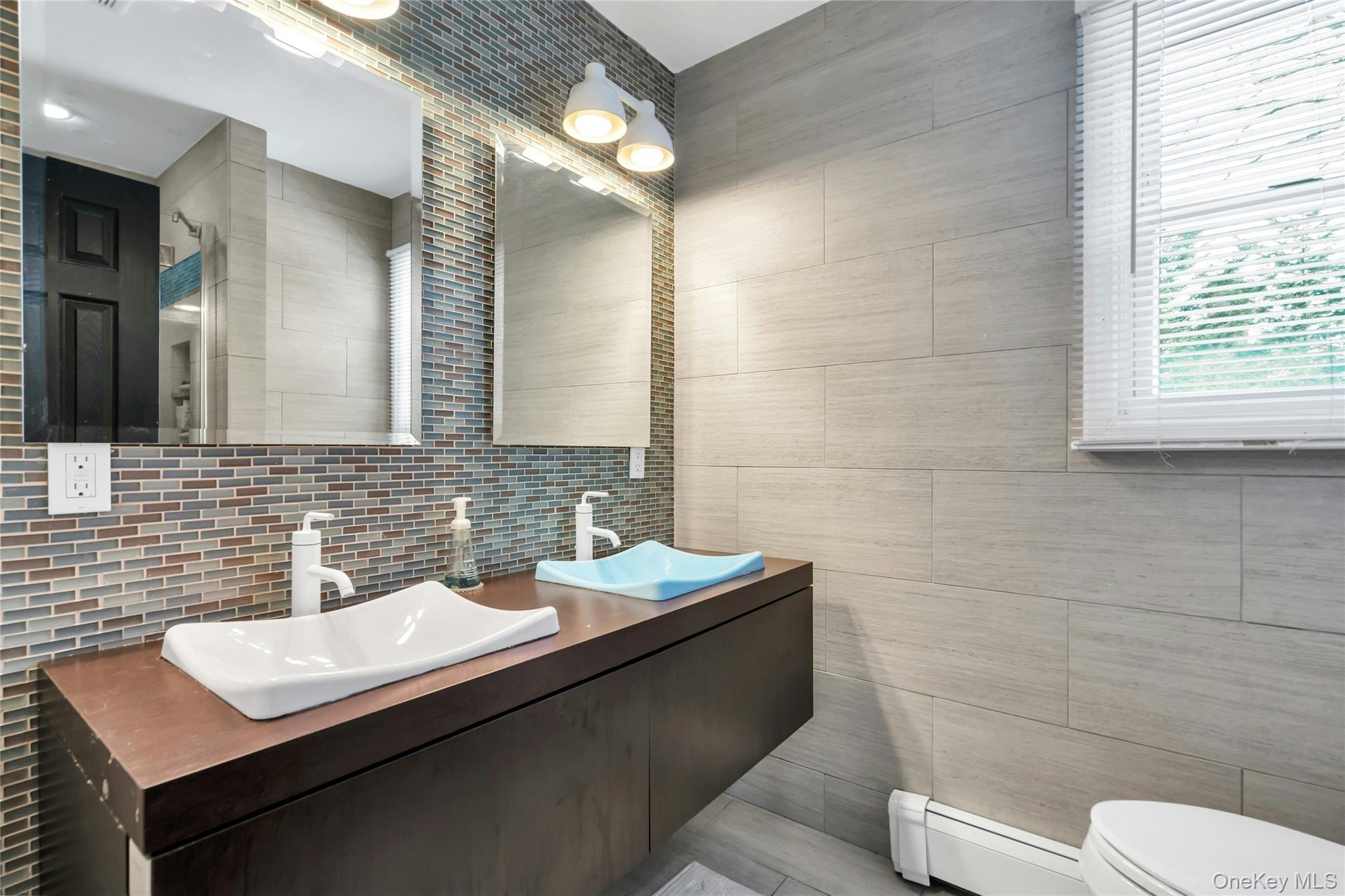 54 Valleywood Road Commack, NY 11725 - Photo 17 of 33 a bathroom with a sink a toilet a mirror and shower