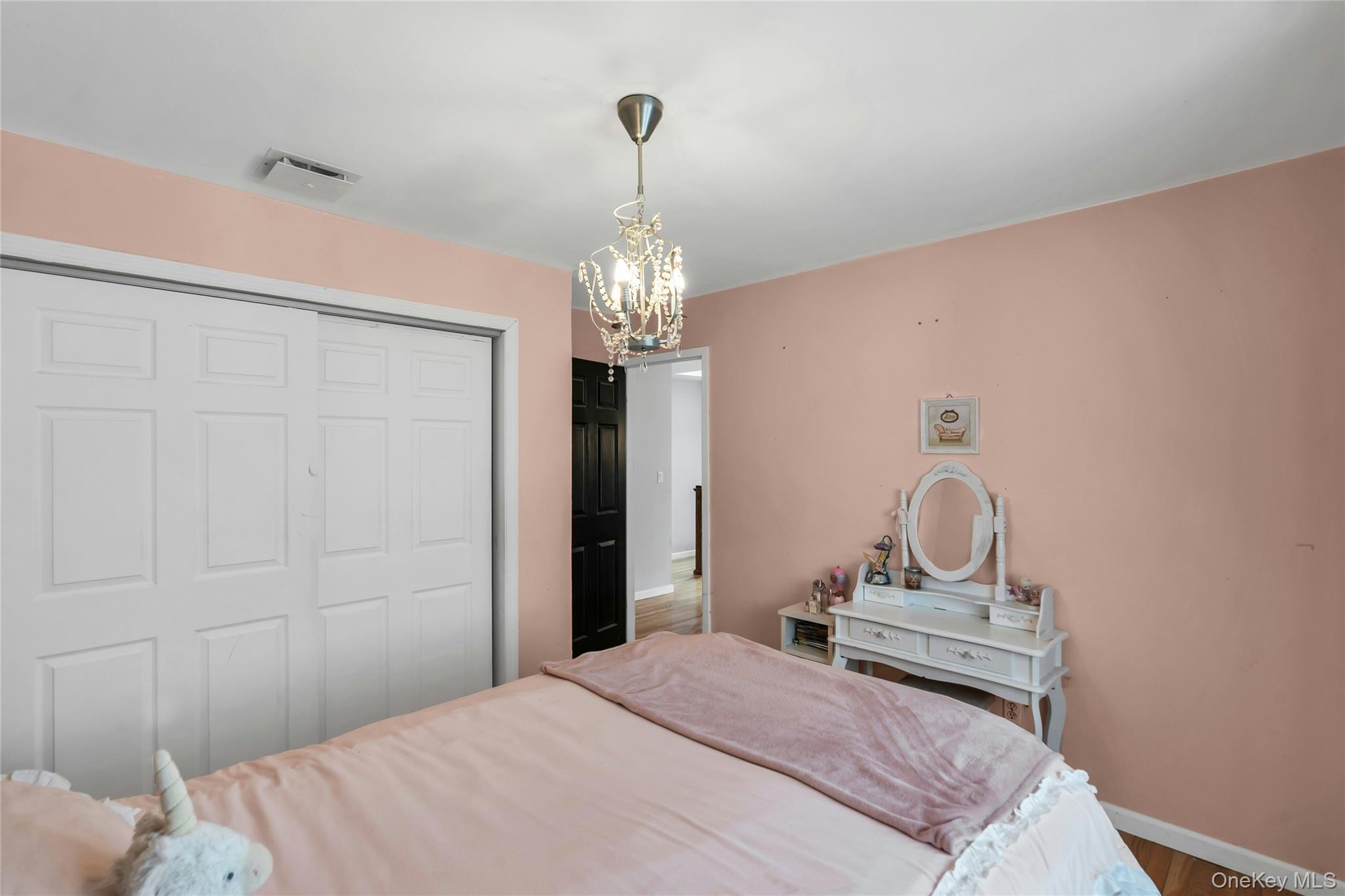 54 Valleywood Road Commack, NY 11725 - Photo 22 of 33 a bedroom with a bed and a chandelier