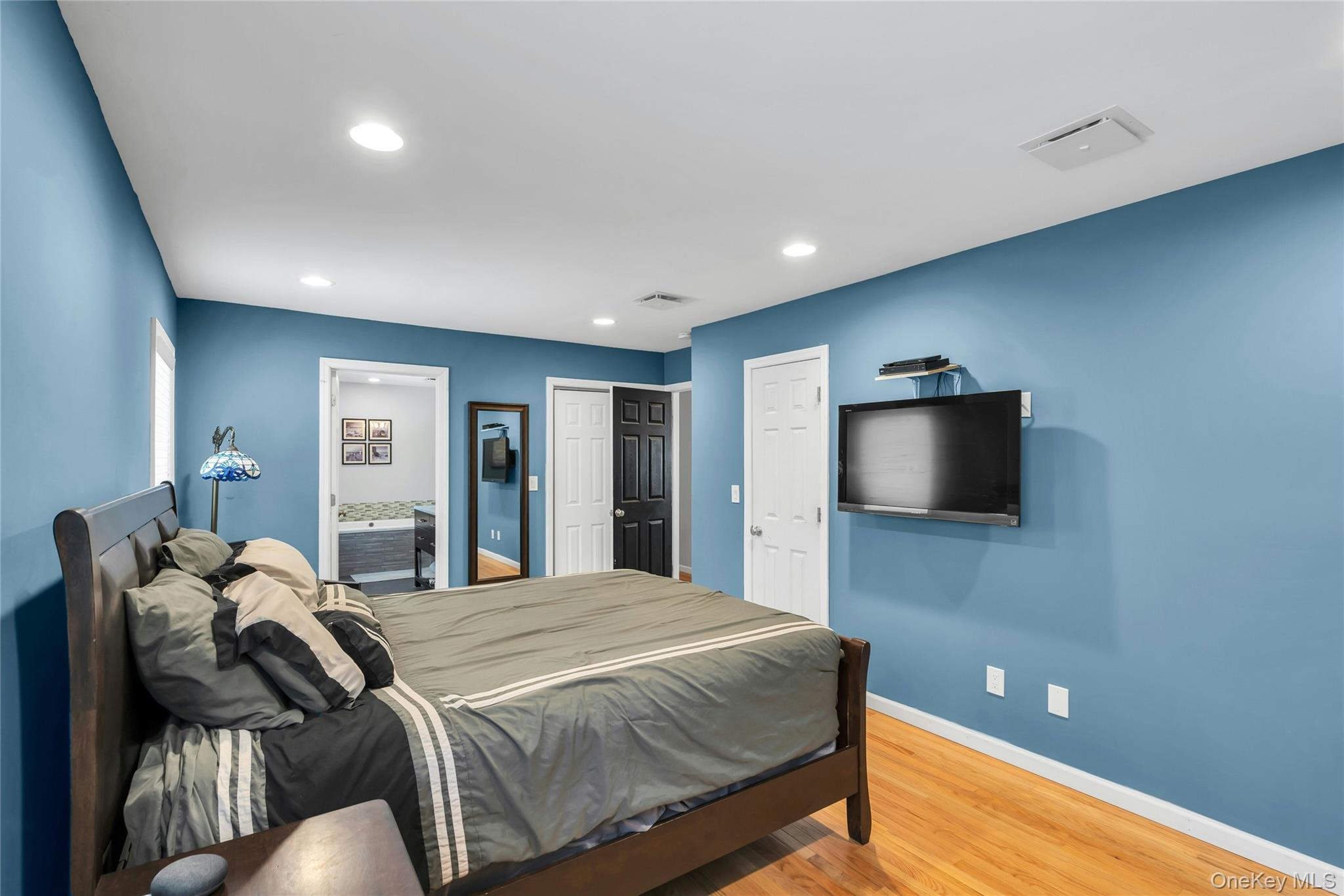 54 Valleywood Road Commack, NY 11725 - Photo 26 of 33 a spacious bedroom with a bed and a flat screen tv